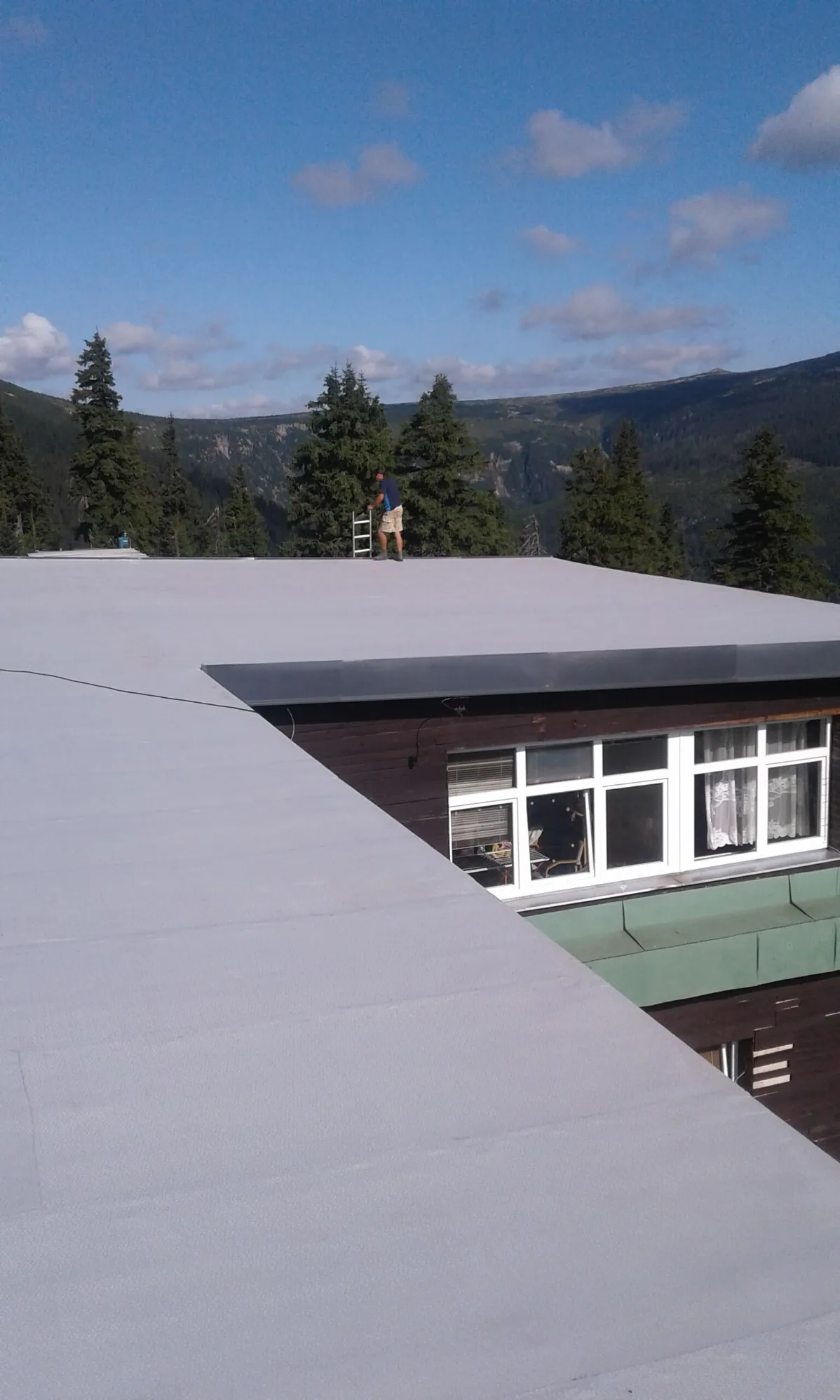 Pracovník provádějící dokončovací práce na nové střešní fólii Protan SE 1,5 mm na horní stanici lanovky na Medvědíně.