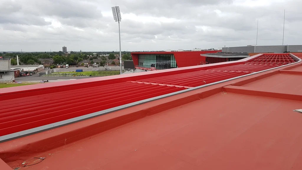 Červená střecha hotelu Hilton Garden Inn s fólií Protan SE a výhledem na tribuny a hrací plochu stadionu Old Trafford Cricket Ground.