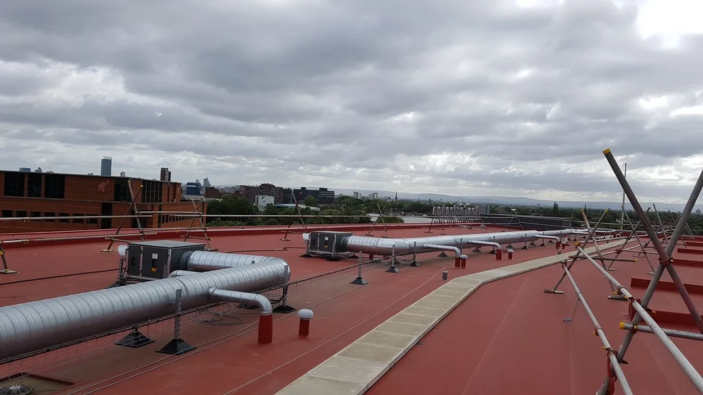 Detail ploché střechy hotelu Hilton Garden Inn s červenou fólií Protan SE a instalovanými technologiemi.