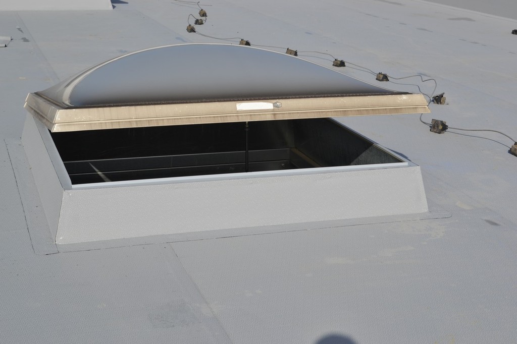 Průběh instalace hydroizolační fólie Protan SE 1,5 mm na střeše výrobní haly, montáž detailů kolem střešních světlíků.