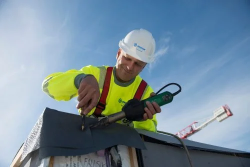 Pracovník provádějící hydroizolaci střechy v Norsku
