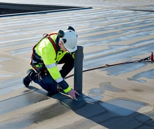 Pracovník provádějící hydroizolaci střechy